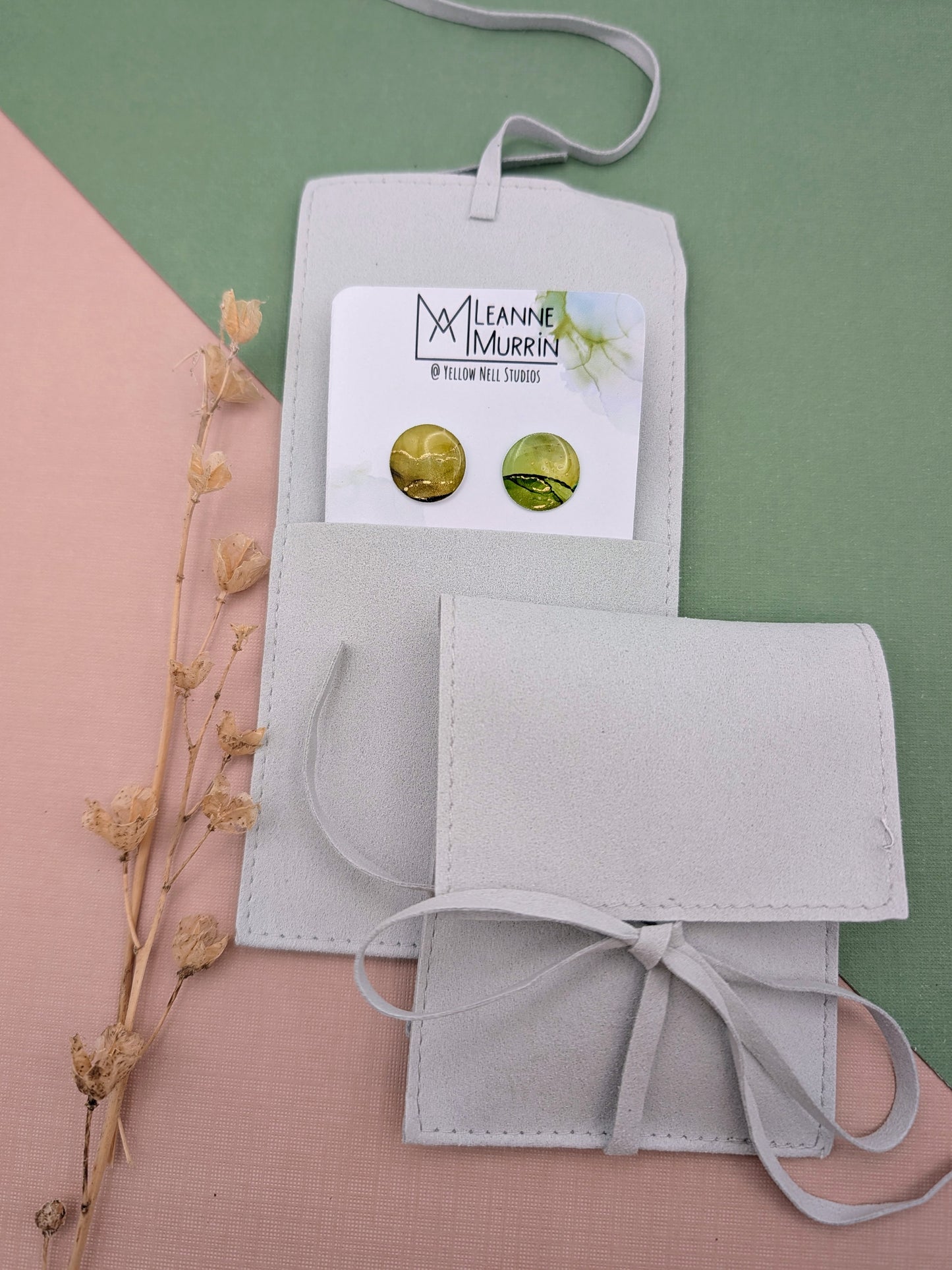 Two gray pouches with a card featuring 'Leanne Murren' branding on a green and pink background.