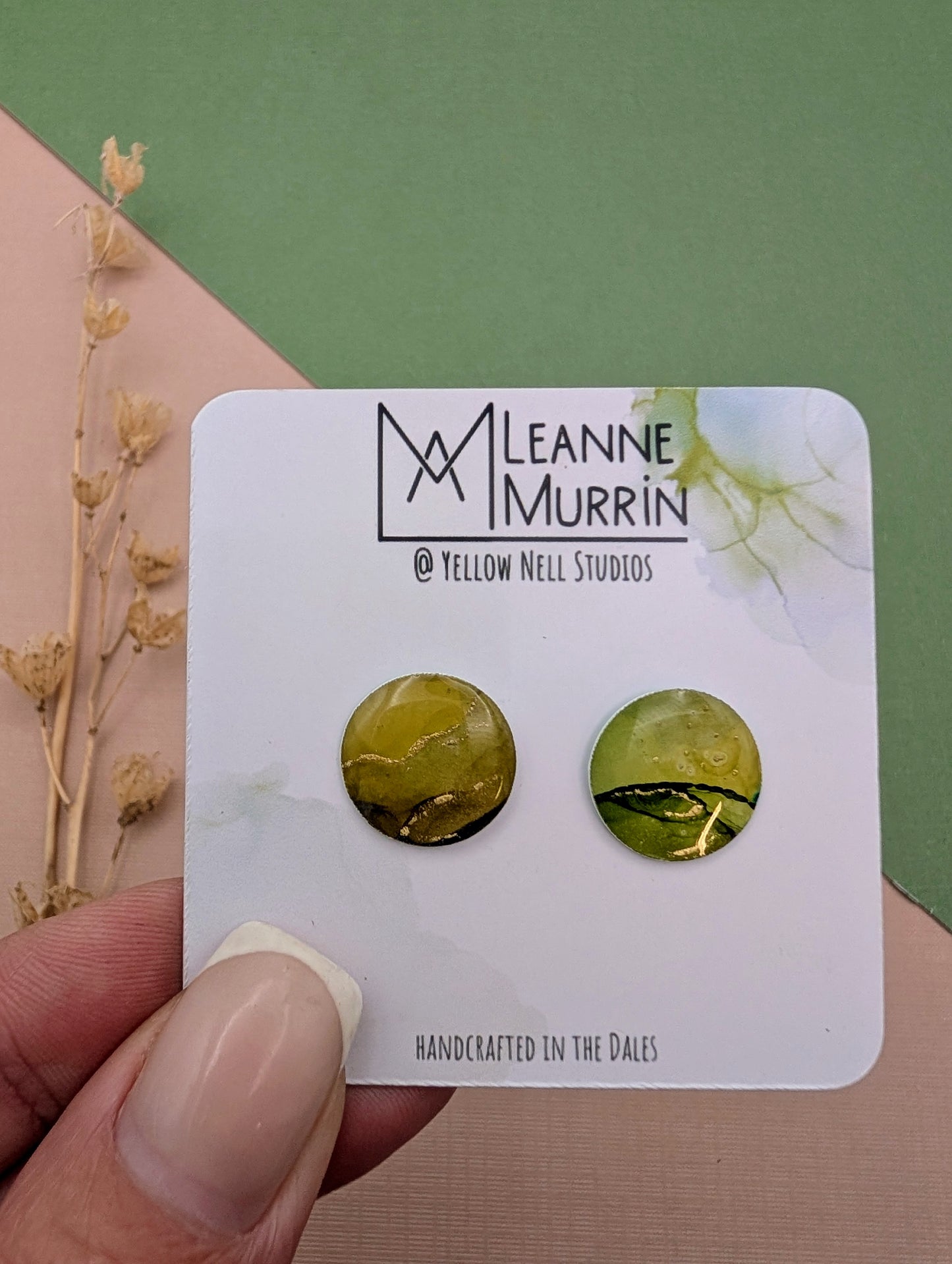 Green marbled earrings on a Leanne Murrin branded card held by a hand.